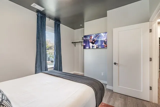 a bedroom with a bed and painting on the wall