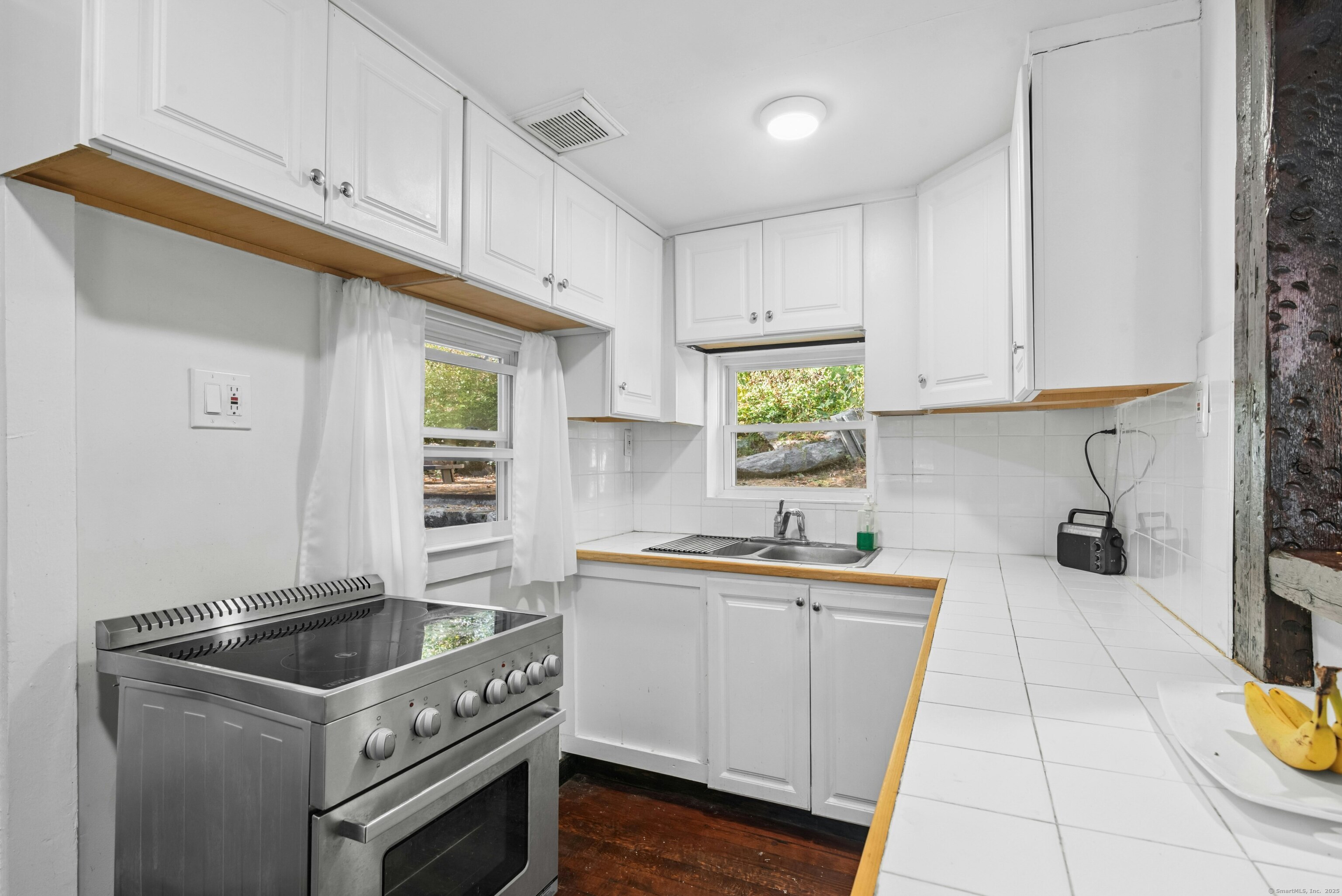 492 Newtown Turnpike Weston, CT 06883 - Photo 7 of 10 a kitchen with a sink a stove cabinets and wooden floor