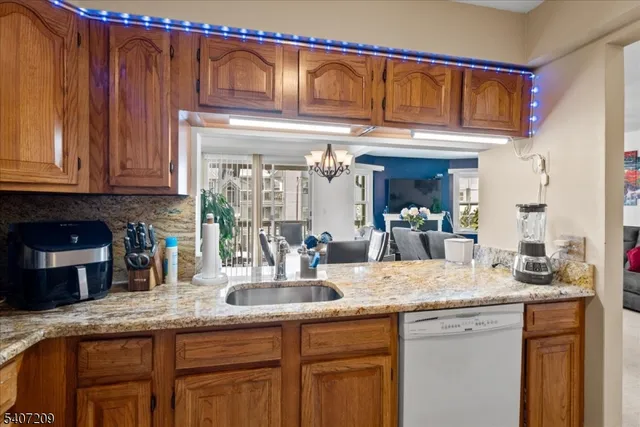 a kitchen with granite countertop a sink and a wooden cabinets