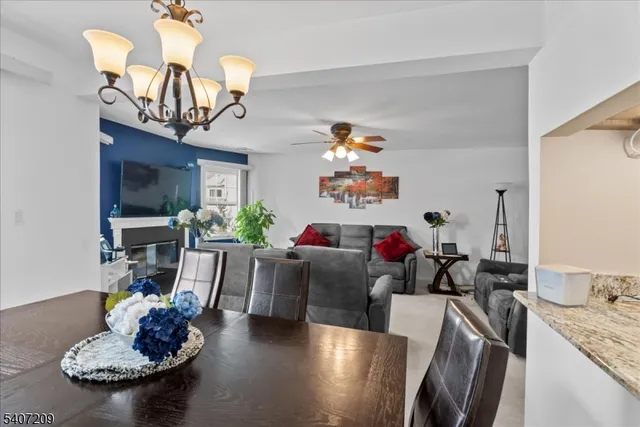 a living room with furniture kitchen view and a wooden floor