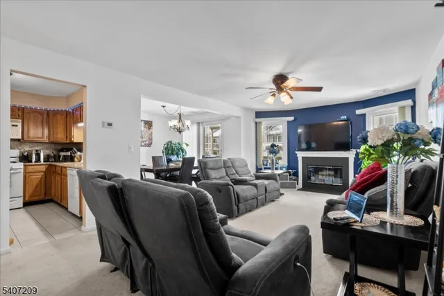 a living room with furniture a flat screen tv and kitchen view