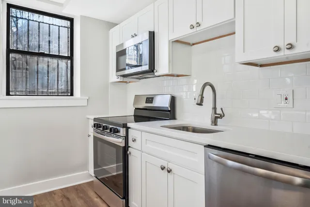 a kitchen with stainless steel appliances granite countertop a sink stove and cabinets