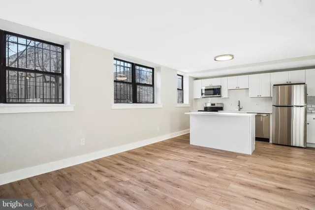 a view of kitchen with wooden floor and electronic appliances