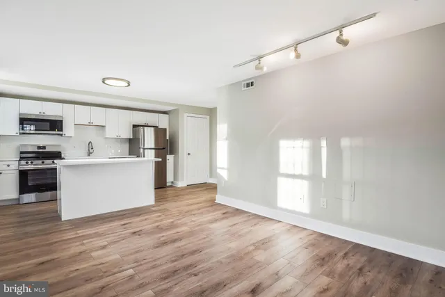a view of a kitchen with wooden floor and electronic appliances