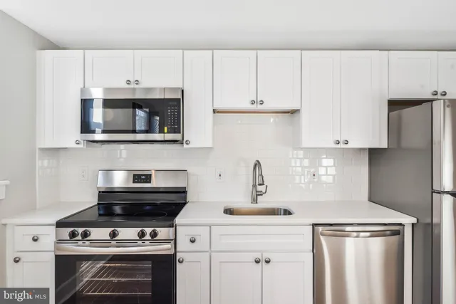 a kitchen with cabinets stainless steel appliances and a sink