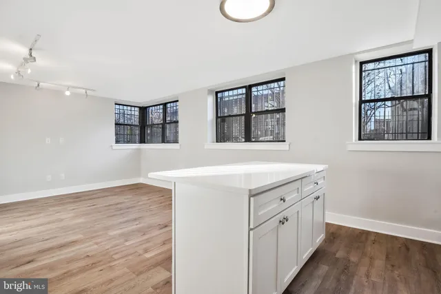 a view of a kitchen with wooden floor and window