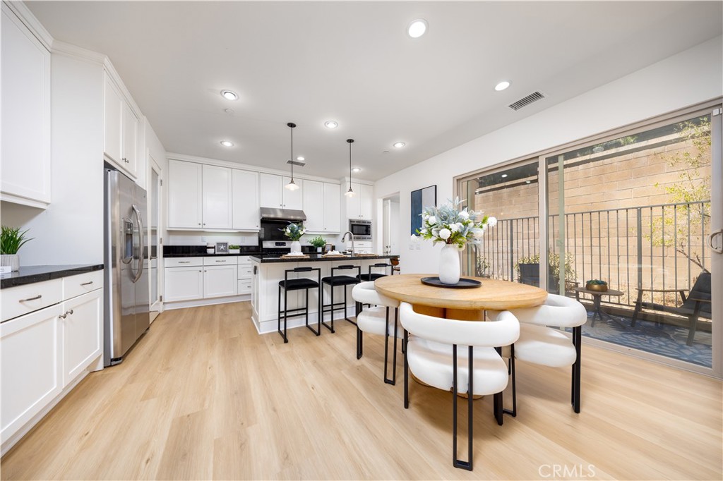 154 Firefly Irvine, CA 92618 - Photo 7 of 34 a kitchen with stainless steel appliances kitchen island granite countertop a table chairs and a refrigerator