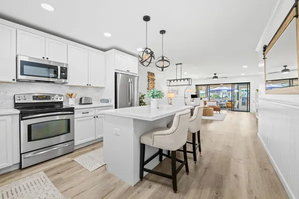 a kitchen with stainless steel appliances granite countertop a stove a sink a microwave a refrigerator and cabinets