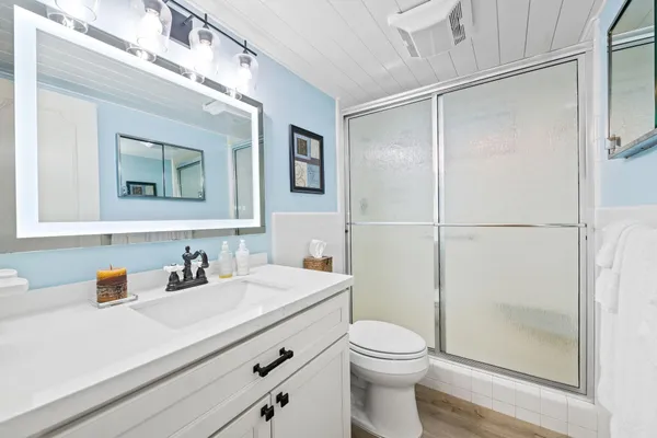 a bathroom with a sink a toilet and shower