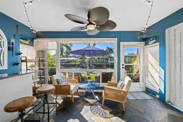 a living room with patio furniture and a floor to ceiling window