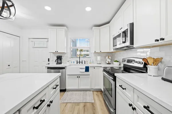 a kitchen with cabinets appliances a sink and a window