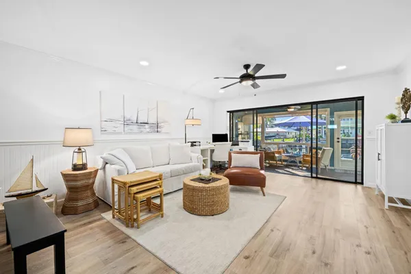 a living room with furniture a flat screen tv and a floor to ceiling window