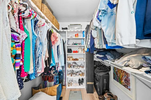 a view of walk in closet with clothes
