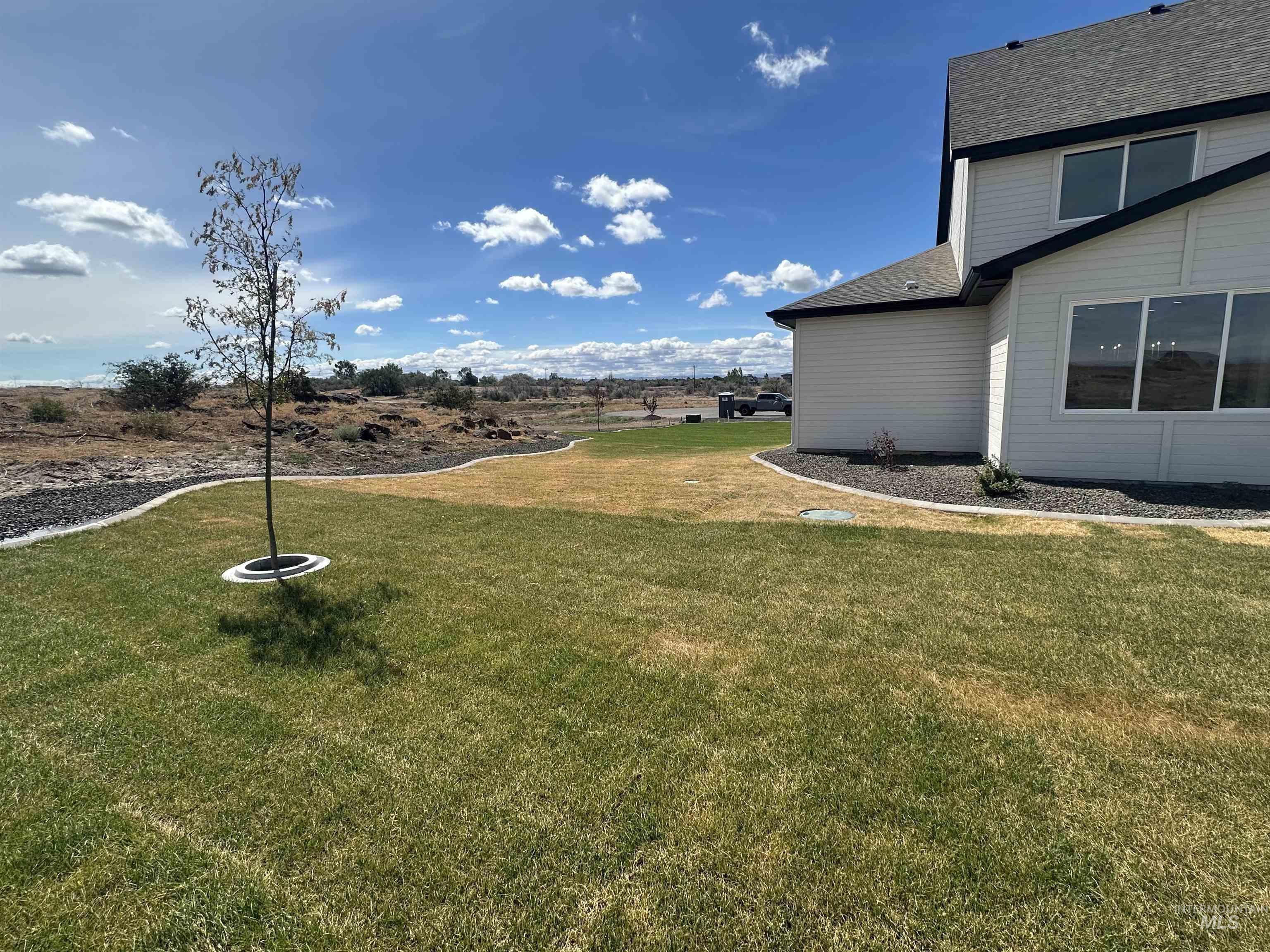 3035 Lake View Twin Falls, ID 83301 - Photo 39 of 41 Expansive outdoor space featuring a young tree, established lawn areas, and decorative rock landscaping