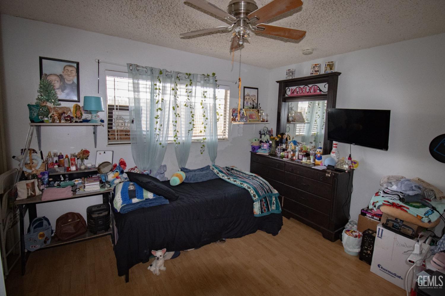 Undisclosed Address Bakersfield, CA 93306 - Photo 5 of 9 a bedroom with bed a flat tv screen and a dresser