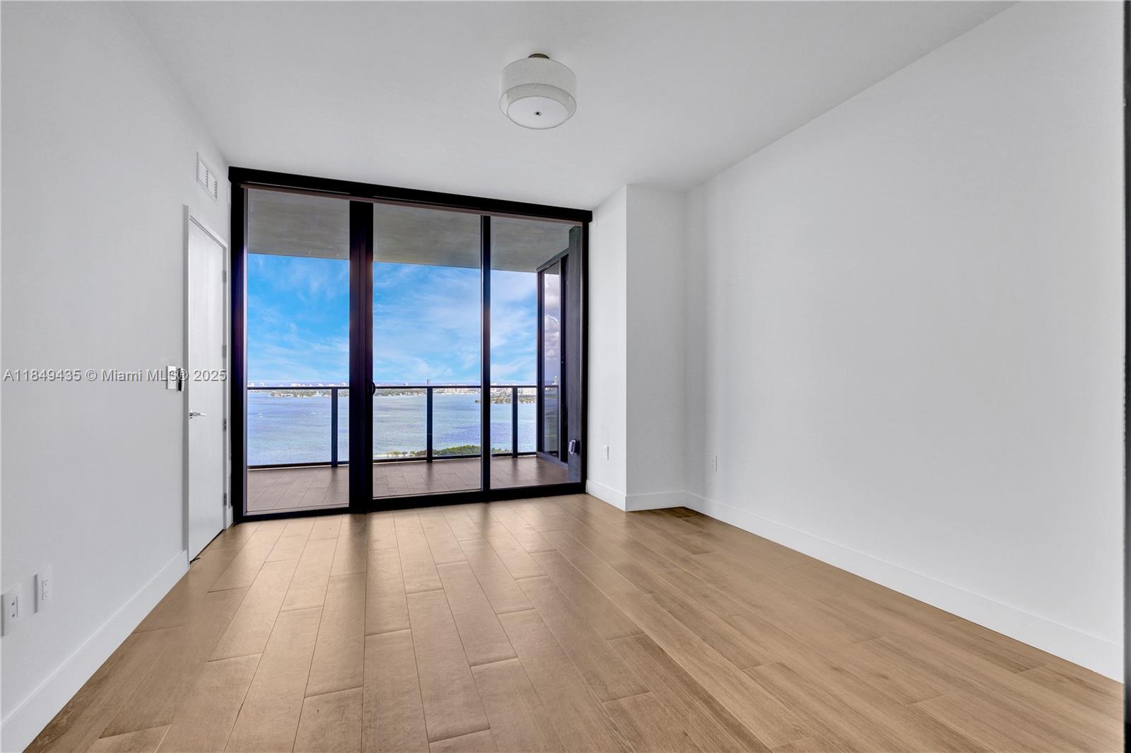 700 Northeast 24th Street, Unit 4005 Miami, FL 33137 - Photo 27 of 89 a view of an empty room with wooden floor and a window