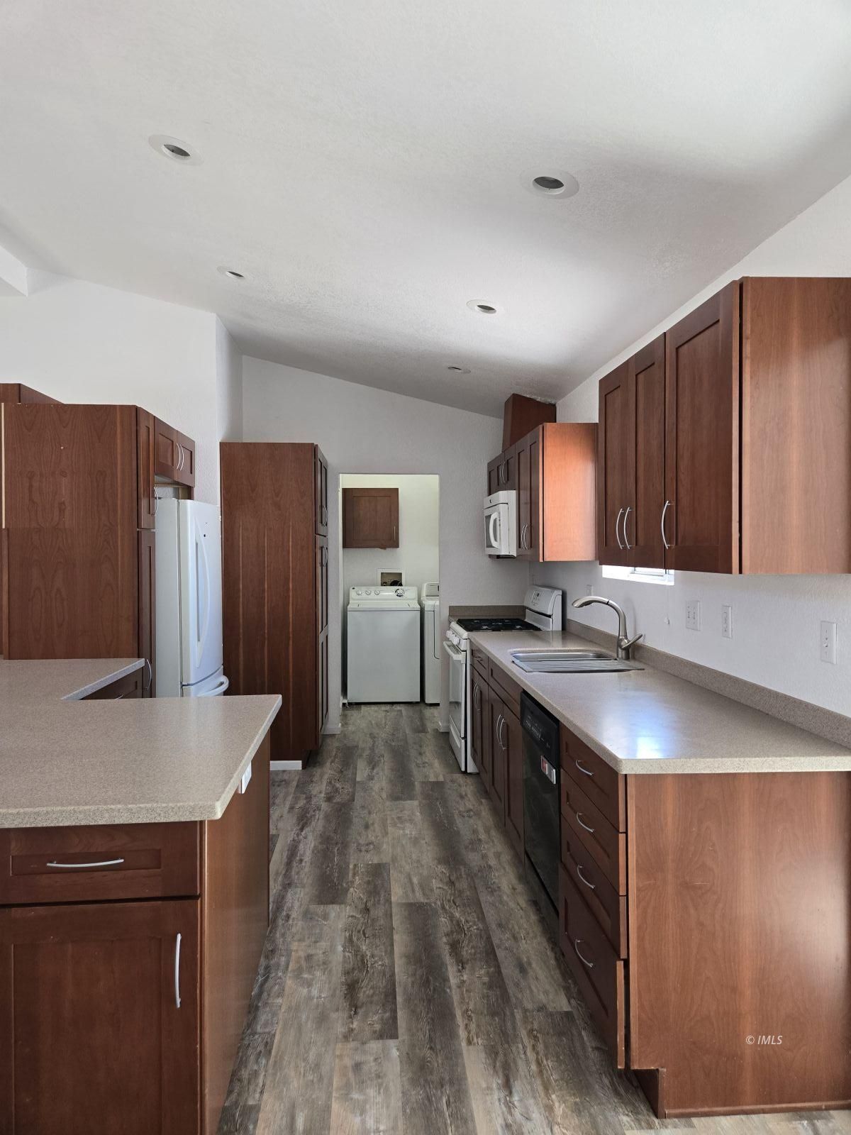 75 Sequoia Street Bishop, CA 93514 - Photo 4 of 21 a large kitchen with stainless steel appliances a large counter top a stove a sink and a refrigerator