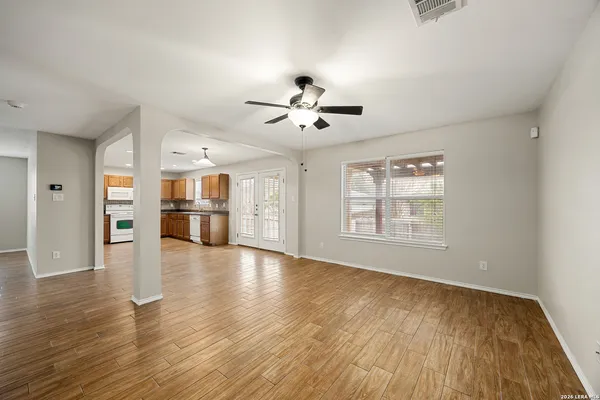 a view of an empty room with window and wooden floor