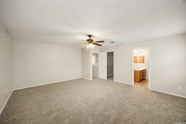 a view of a big room with windows and chandelier fan