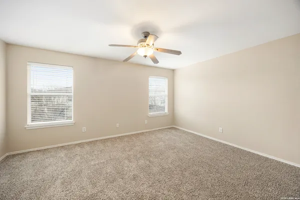 an empty room with a window and a fan