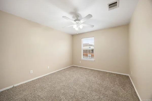 an empty room with a window and a fan
