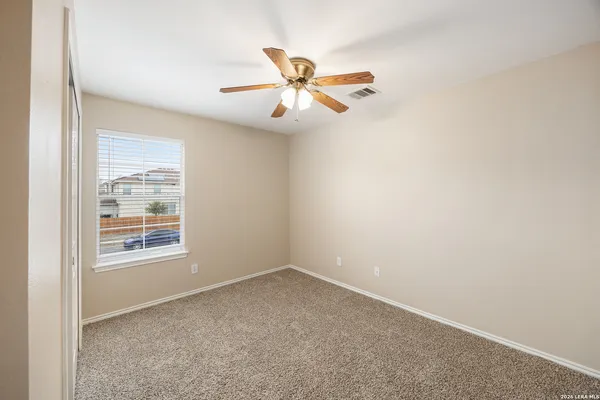 an empty room with a window and a fan