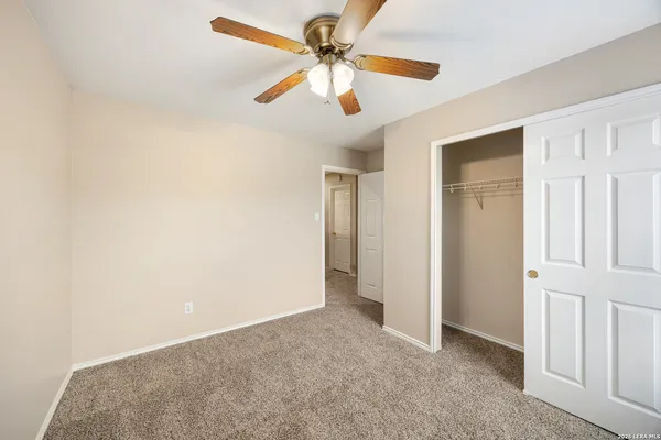 a view of a livingroom with a ceiling fan and carpet