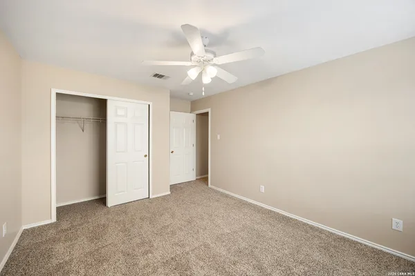 an empty room with a ceiling fan and a window