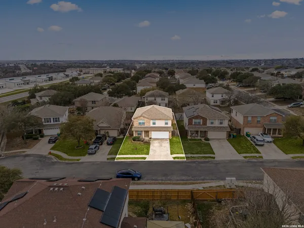 an aerial view of residential houses with outdoor space and parking