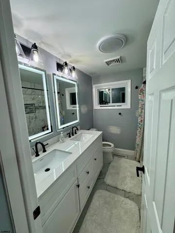 a spacious bathroom with a double vanity sink mirror and toilet