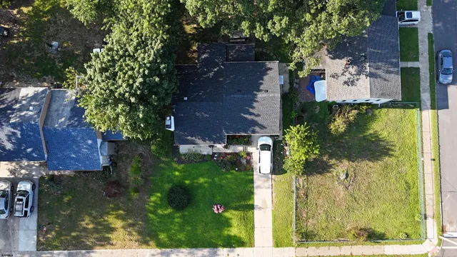 an aerial view of residential houses with outdoor space and trees