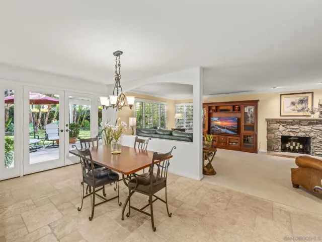 a kitchen with granite countertop a refrigerator a stove a sink a dining table and chairs