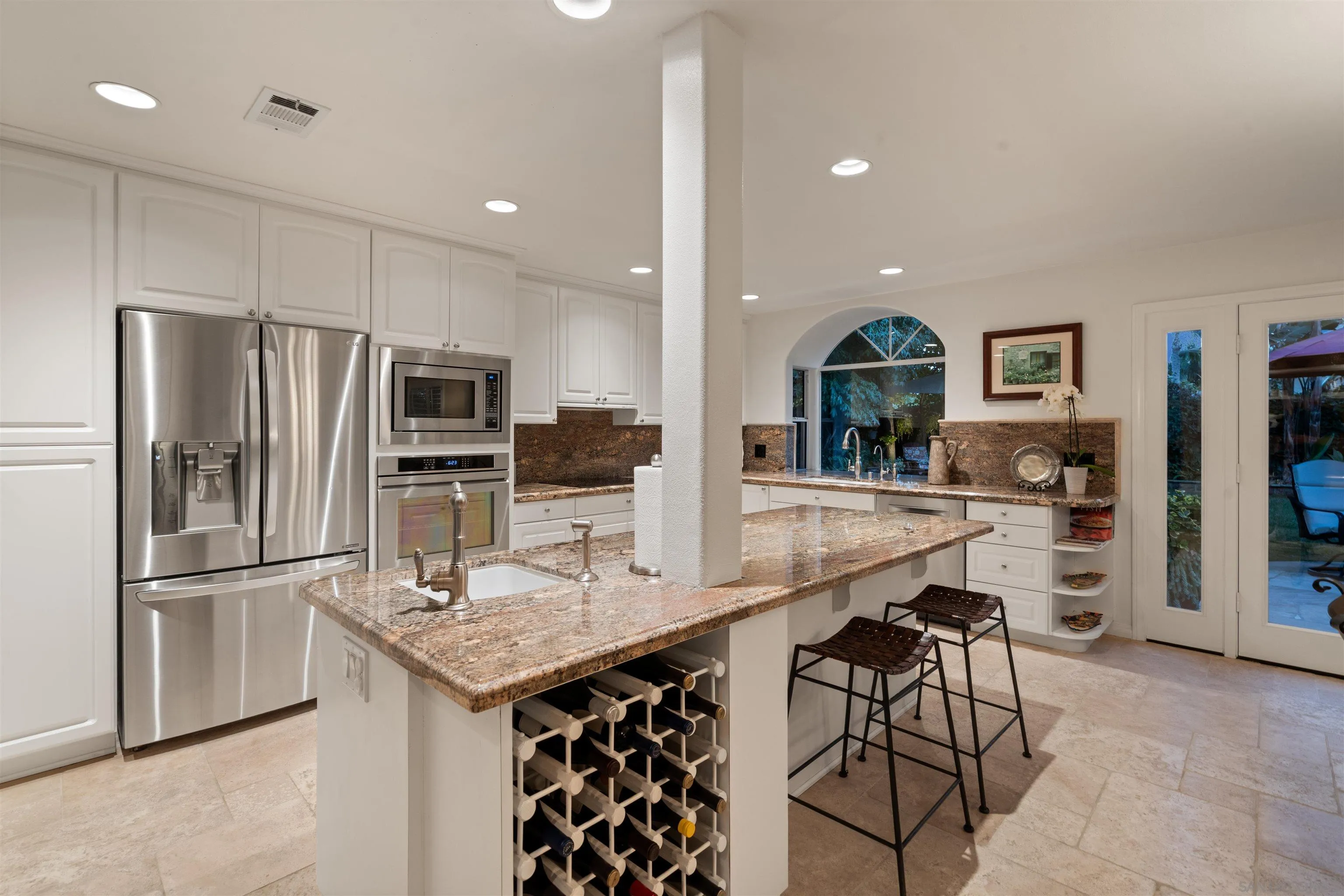 6502 La Paloma Street Carlsbad, CA 92009 - Photo 15 of 60 a kitchen with granite countertop a refrigerator a stove a sink a dining table and chairs