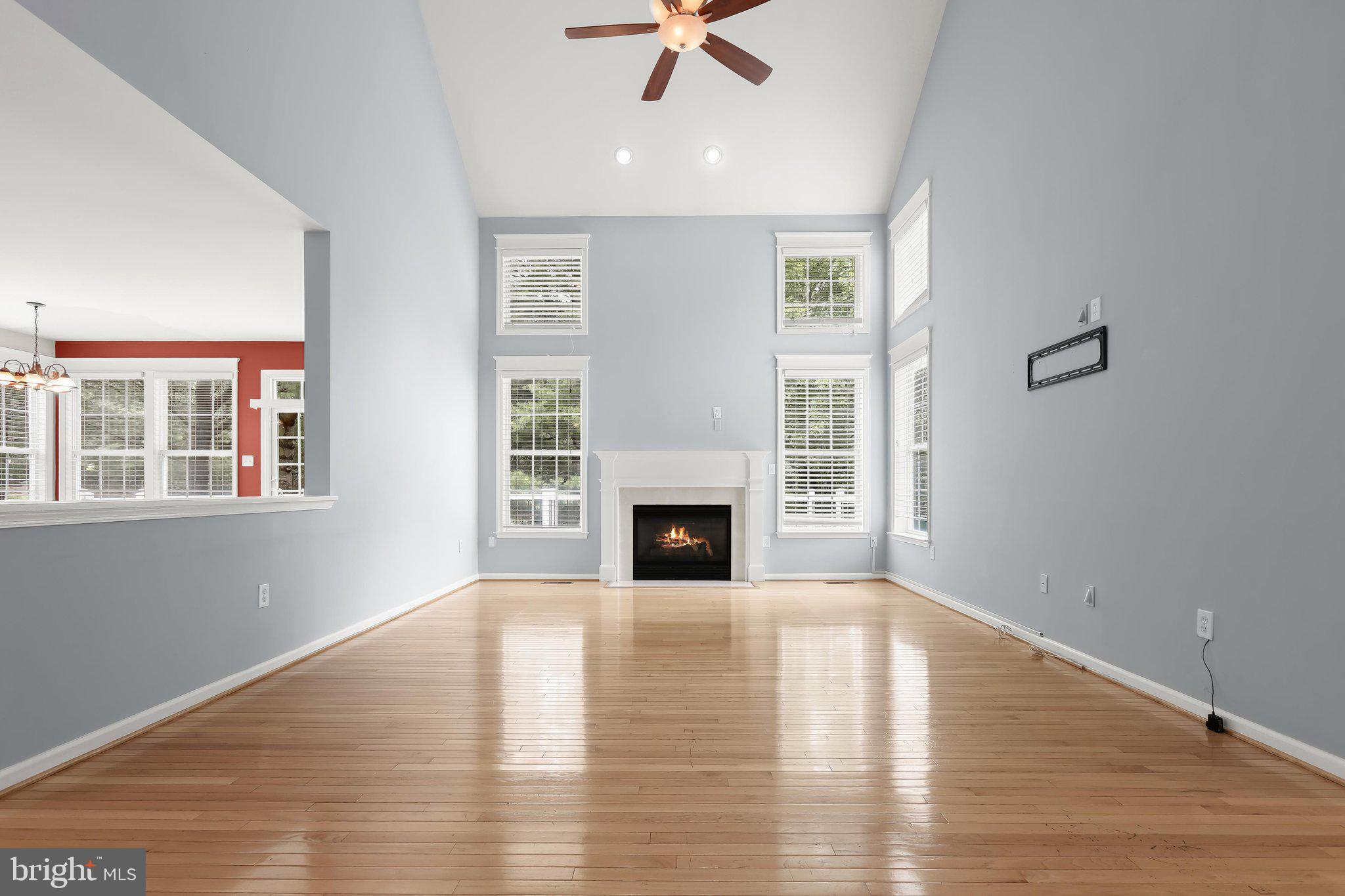 6111 Rippling Tides Terrace Clarksville, MD 21029 - Photo 34 of 84 a view of a livingroom with a fireplace a ceiling fan and windows