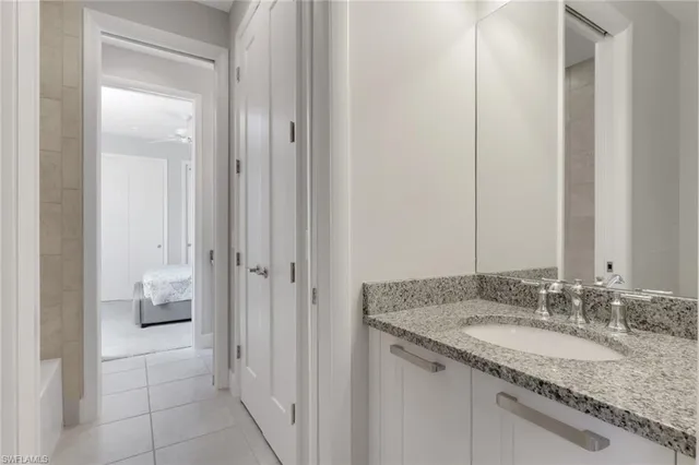 a bathroom with a granite countertop sink and a mirror