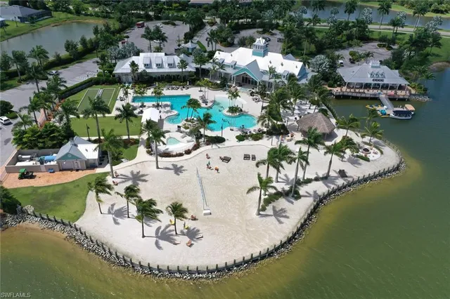 an aerial view of a house with a lake boats and trees all around