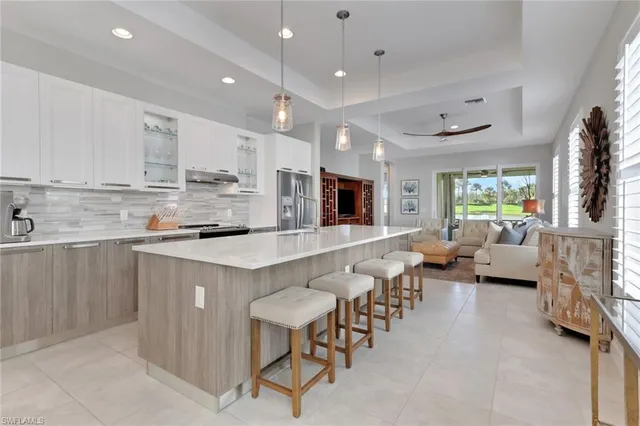 a large kitchen with lots of counter top space a sink stainless steel appliances and cabinets