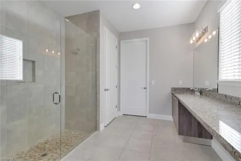 a bathroom with a granite countertop sink and shower