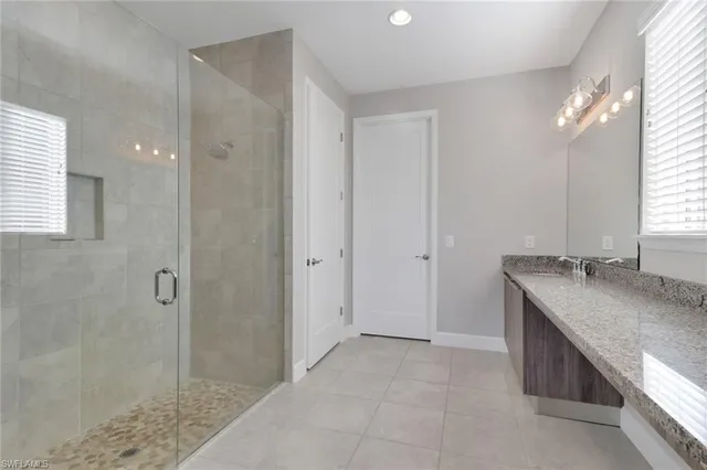a bathroom with a granite countertop sink and shower