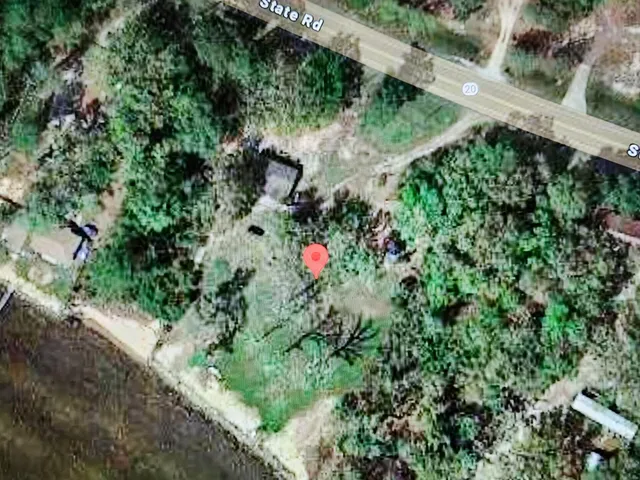 an aerial view of residential house with outdoor space and trees all around