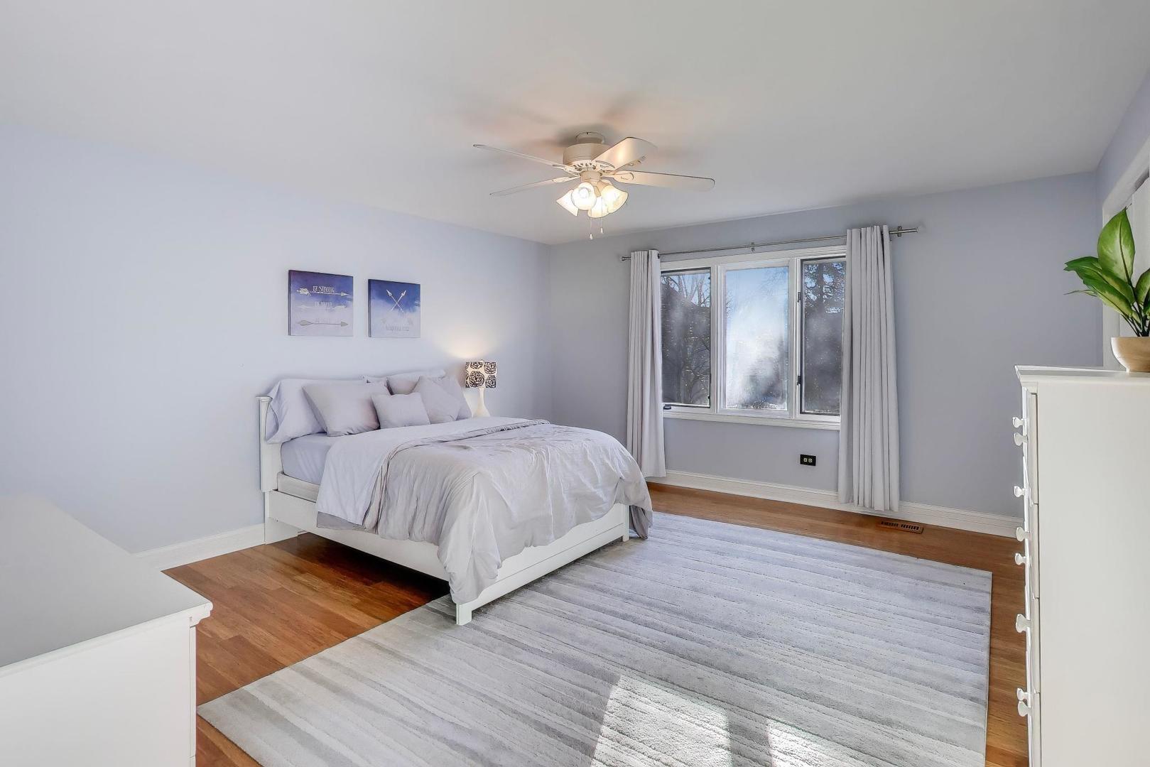 2103 Primrose Lane Naperville, IL 60565 - Photo 19 of 40 a bedroom with a bed lamp and a potted plant