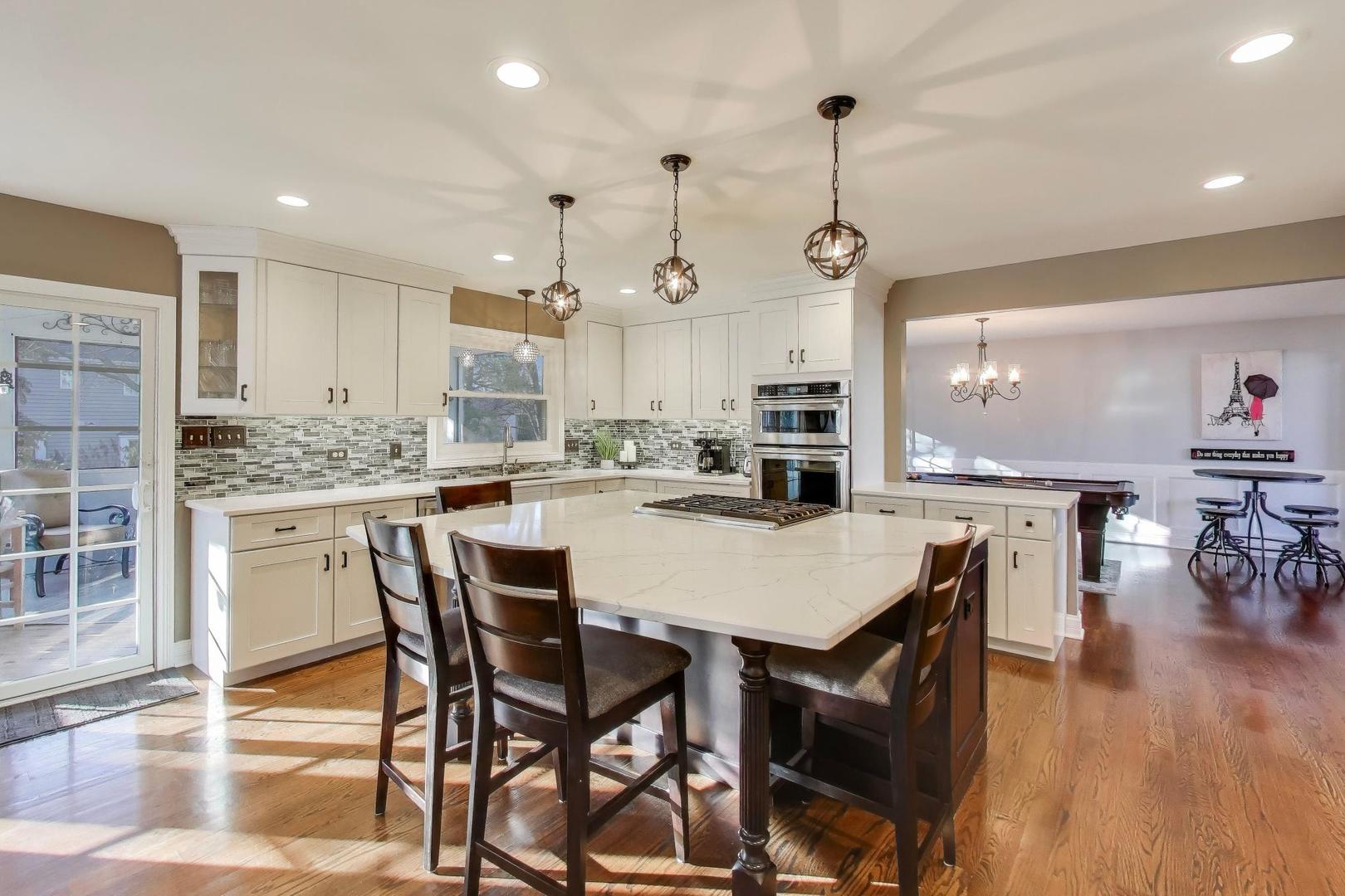 2103 Primrose Lane Naperville, IL 60565 - Photo 2 of 40 a kitchen with stainless steel appliances kitchen island granite countertop a dining table chairs and white cabinets
