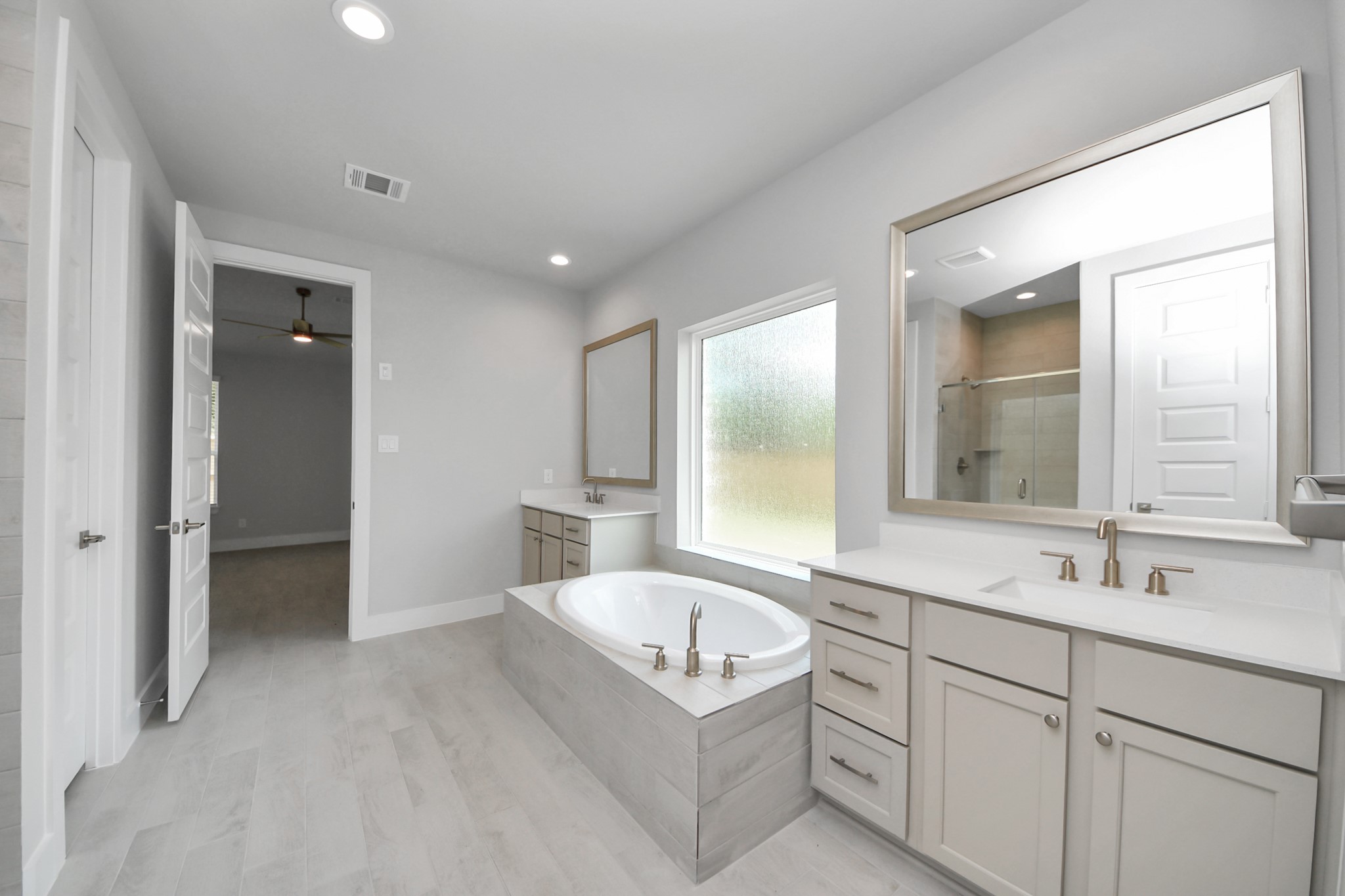 3043 Native Spg Drive Spring, TX 77373 - Photo 25 of 45 Elevate your daily routine at the elegant vanity, now equipped with double sinks, light countertops, modern hardware, and beautiful recessed lights.