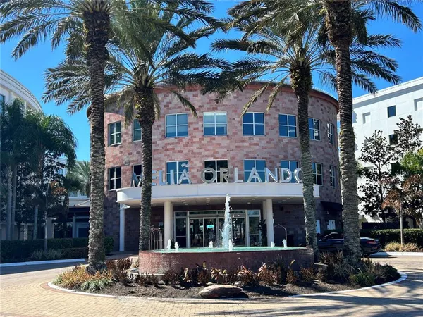 a view of a white building among the street with palm trees