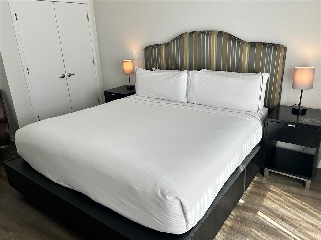 225 Celebration Place, Unit 446 Kissimmee, FL 34747 - Photo 11 of 17 a large bed sitting in a bedroom next to a lamp