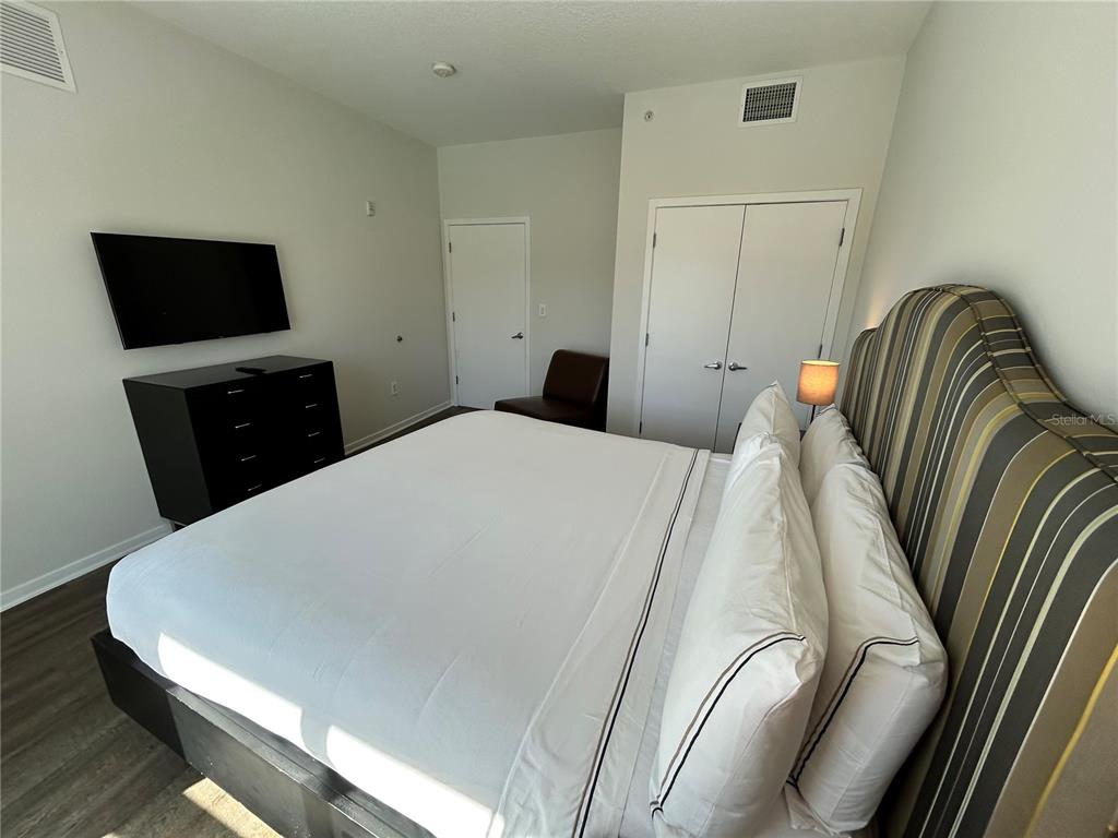 225 Celebration Place, Unit 446 Kissimmee, FL 34747 - Photo 12 of 17 a bedroom with a bed and a flat screen tv