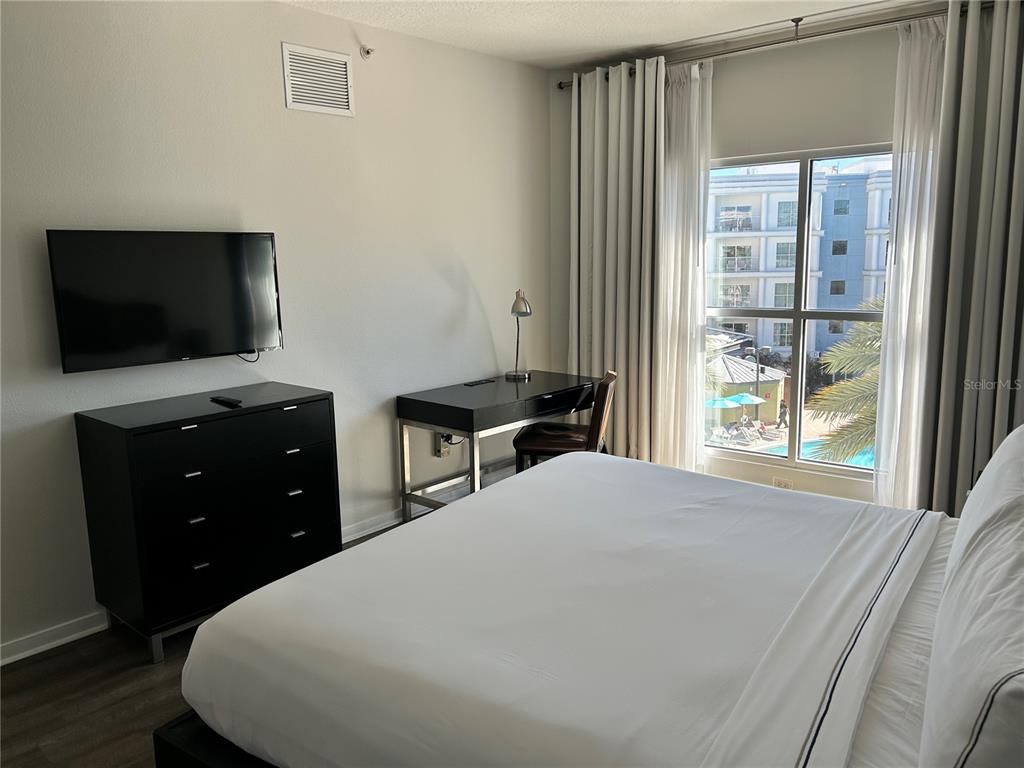 225 Celebration Place, Unit 446 Kissimmee, FL 34747 - Photo 7 of 17 a bedroom with a bed and a flat screen tv