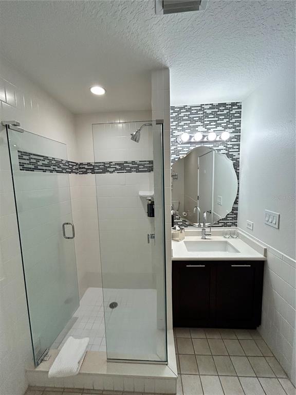 225 Celebration Place, Unit 446 Kissimmee, FL 34747 - Photo 9 of 17 a bathroom with a granite countertop sink a mirror and shower