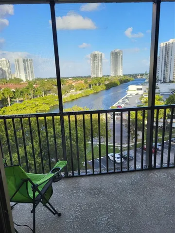 a view of a porch with furniture and floor to ceiling window