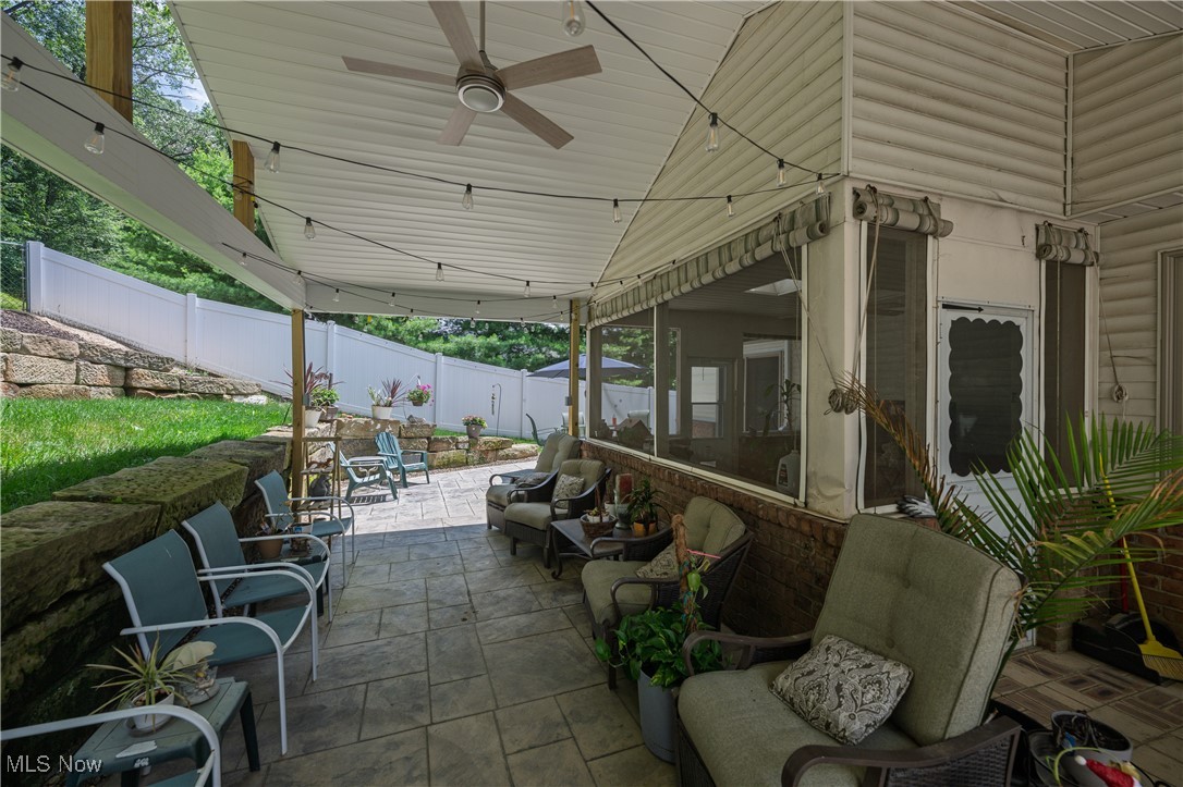 Fenced backyard with a patio area and a ceiling fan